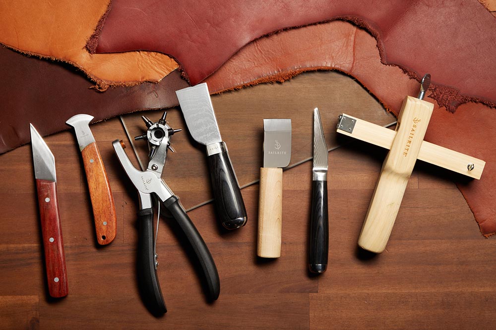 From left: French angled knife, mini round knife, rotary hole punch, Damascus skiving knife, utility knife and a strap cutter.